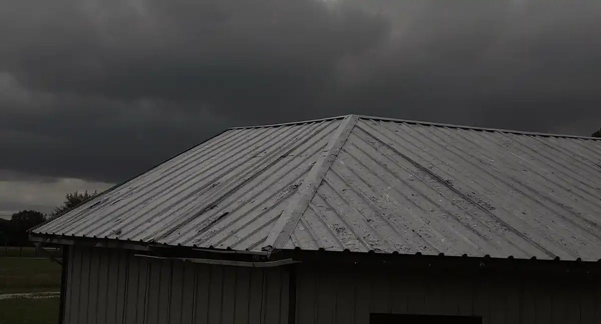 Hail-dented metal roof on rural building in Midland, Kansas